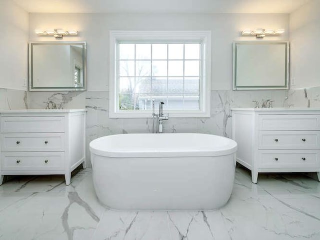 bathroom with vanity, a bath, and tile walls