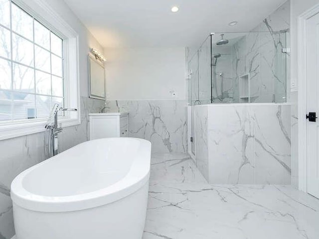 bathroom with vanity, separate shower and tub, and tile walls