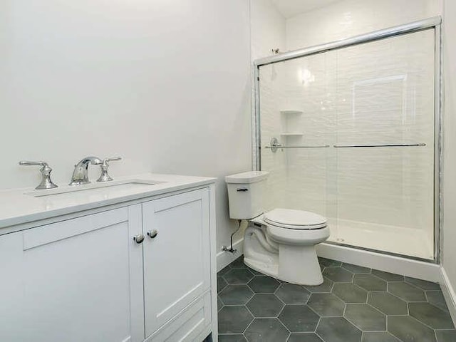 bathroom featuring an enclosed shower, vanity, tile patterned flooring, and toilet