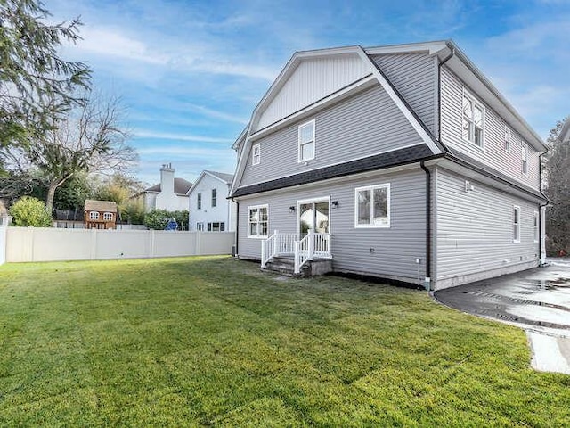 rear view of property featuring a yard