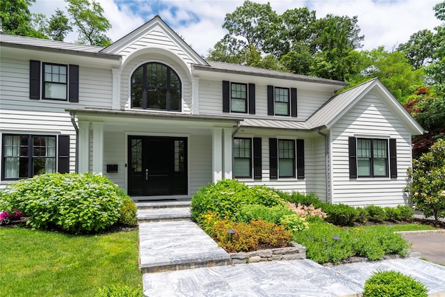 view of front of property featuring a standing seam roof, metal roof, and covered porch