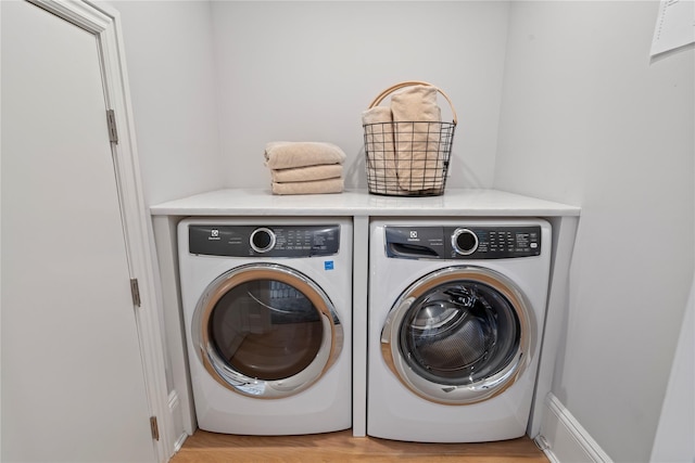 laundry room with light wood-type flooring, laundry area, and washer and dryer