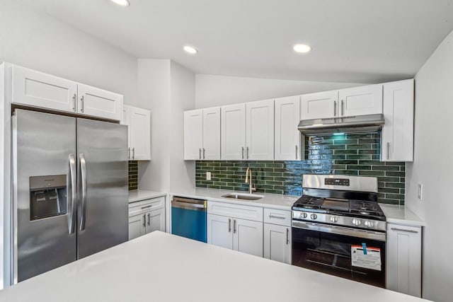 kitchen with sink, white cabinetry, tasteful backsplash, vaulted ceiling, and stainless steel appliances