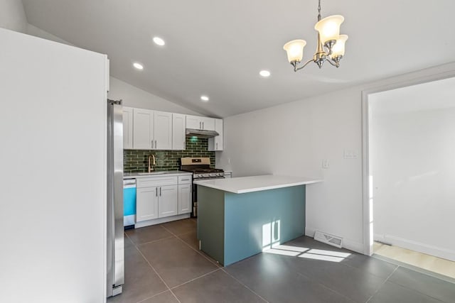 kitchen with sink, appliances with stainless steel finishes, white cabinetry, backsplash, and decorative light fixtures