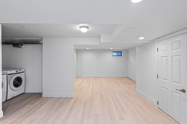 basement featuring washing machine and dryer and light hardwood / wood-style flooring