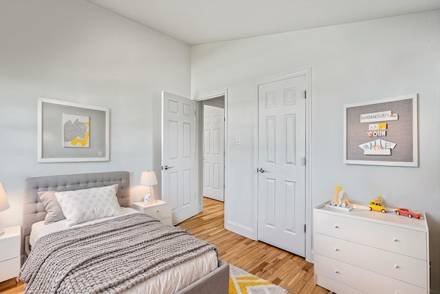 bedroom with vaulted ceiling and light hardwood / wood-style floors