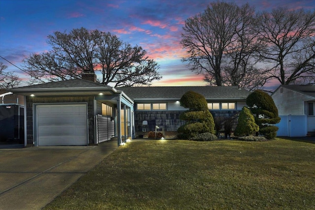 view of front of house with a garage and a yard