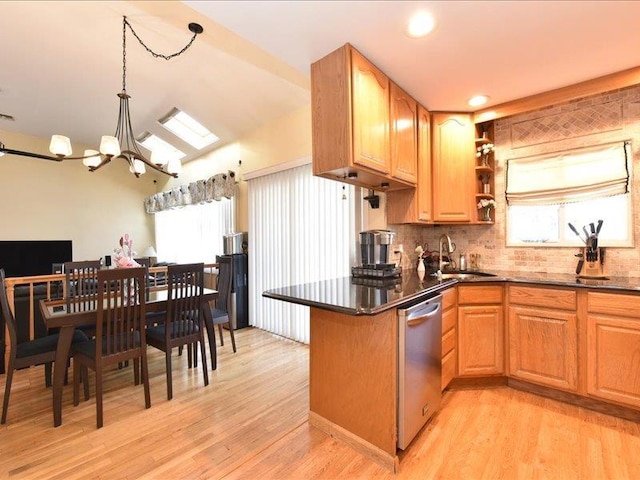 kitchen with sink, stainless steel dishwasher, a notable chandelier, and light hardwood / wood-style floors