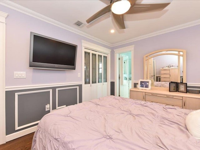 bedroom with crown molding, dark hardwood / wood-style floors, ceiling fan, and ensuite bath