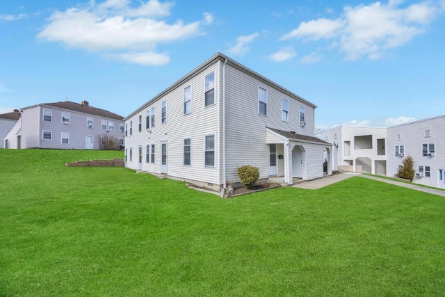 rear view of house featuring a lawn and a residential view