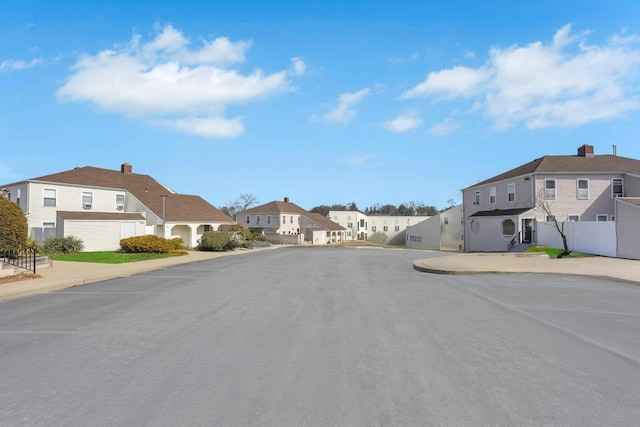 view of street with sidewalks, a residential view, and curbs