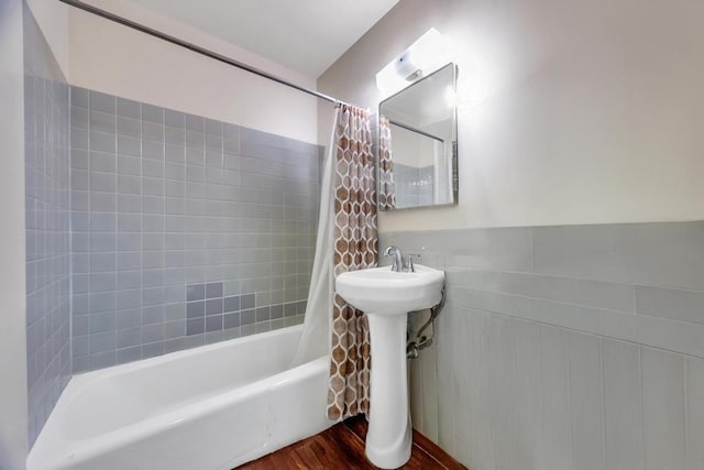 bathroom with shower / bath combo with shower curtain and wood finished floors