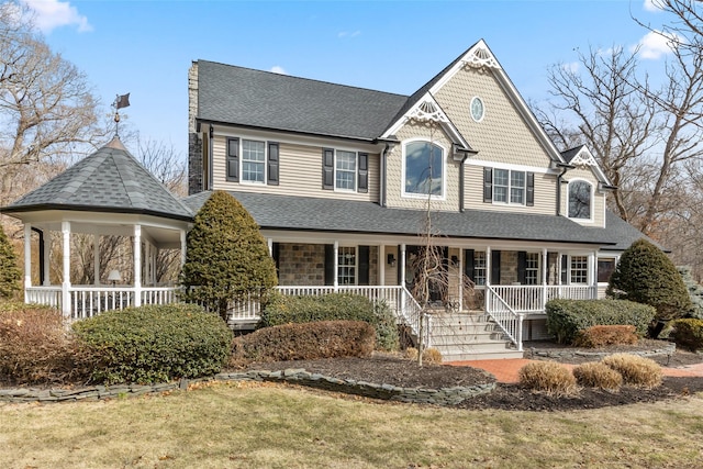 view of front of home with a porch and a shingled roof