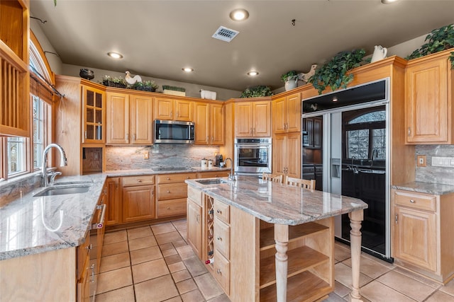 kitchen featuring light tile patterned floors, black appliances, a sink, and visible vents