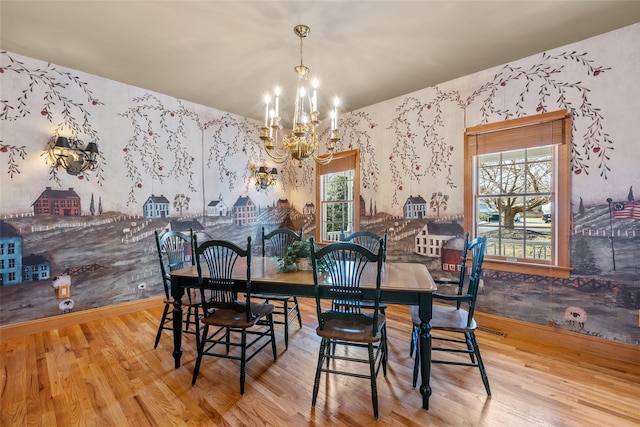 dining room featuring wallpapered walls, a notable chandelier, baseboards, and wood finished floors