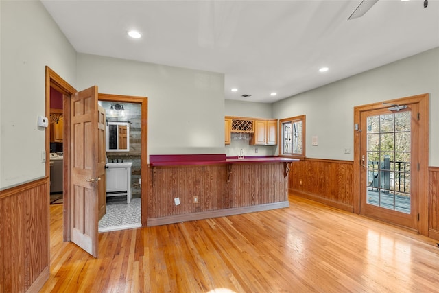 kitchen with recessed lighting, a peninsula, light wood-style floors, wainscoting, and washer / clothes dryer