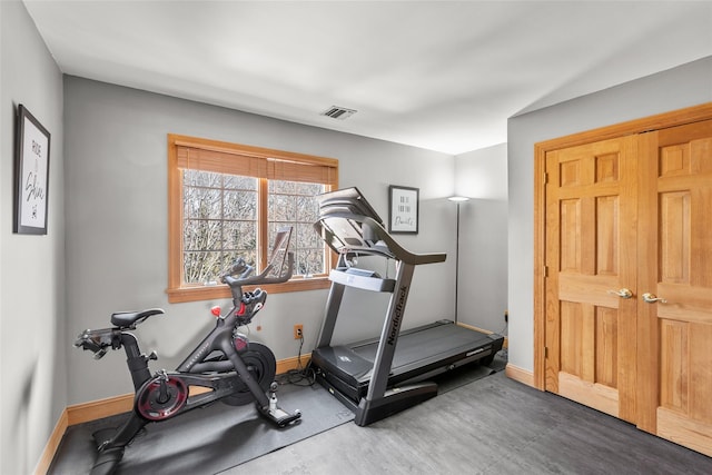 workout area featuring visible vents, baseboards, and wood finished floors