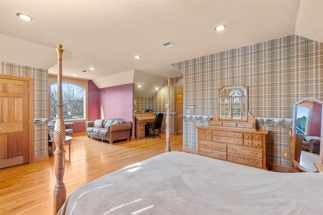 bedroom with lofted ceiling, recessed lighting, visible vents, wood finished floors, and wallpapered walls