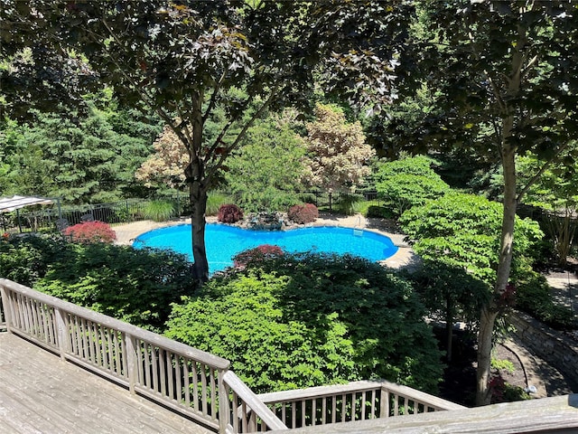 view of pool with a fenced in pool, fence, and a deck