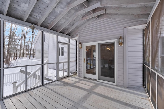 unfurnished sunroom featuring lofted ceiling with beams