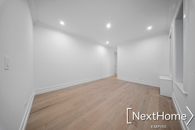 unfurnished room with ornamental molding and light wood-type flooring