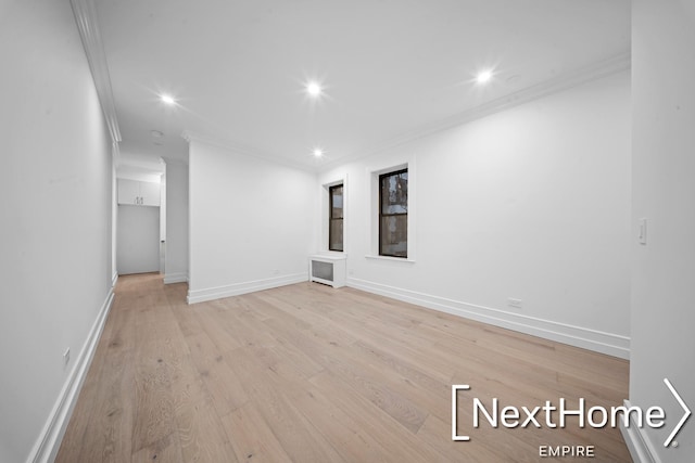 spare room featuring crown molding and light hardwood / wood-style floors