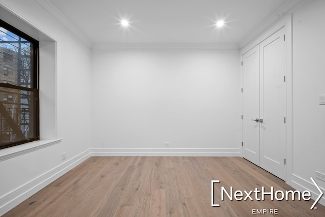 unfurnished room featuring crown molding and light wood-type flooring