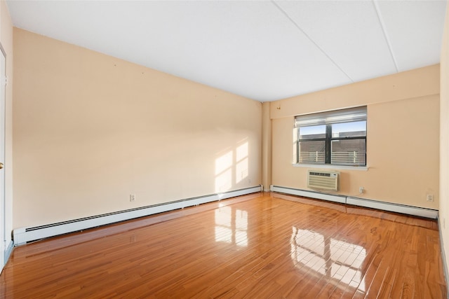 unfurnished room featuring hardwood / wood-style flooring, a baseboard radiator, and a wall unit AC