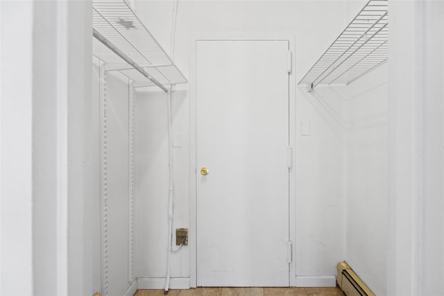 walk in closet with a baseboard radiator