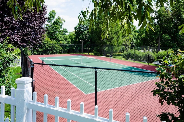 view of tennis court featuring fence