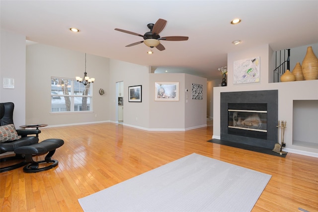 living area with baseboards, a tile fireplace, wood finished floors, vaulted ceiling, and recessed lighting