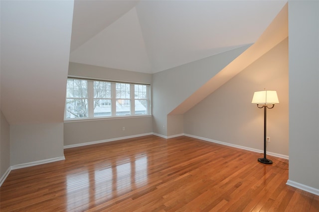 bonus room featuring vaulted ceiling, wood finished floors, and baseboards