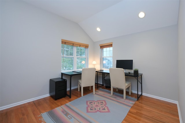 office featuring lofted ceiling, baseboards, and wood finished floors