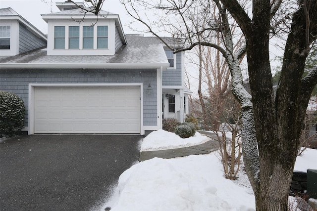 view of front of house featuring aphalt driveway and a shingled roof