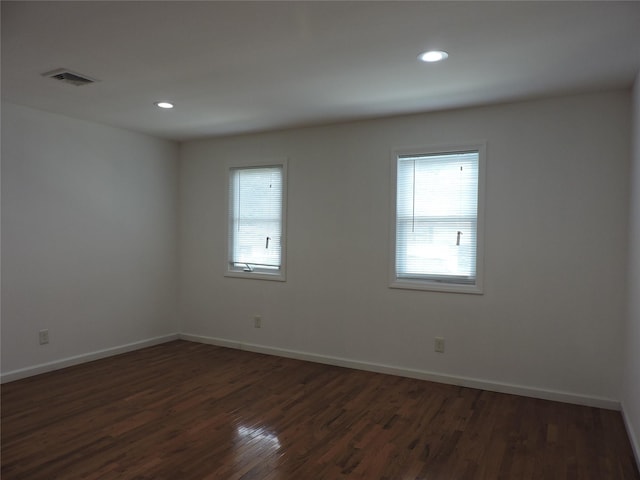 unfurnished room with a healthy amount of sunlight and dark hardwood / wood-style flooring