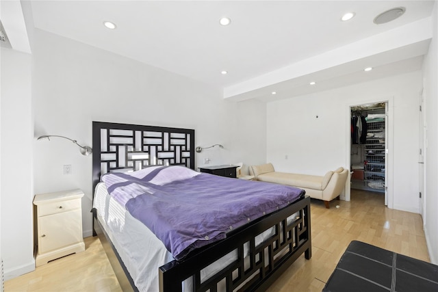 bedroom featuring a walk in closet and light wood-type flooring