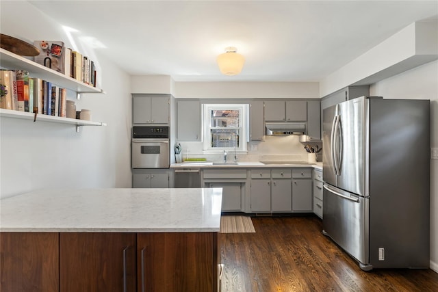 kitchen with under cabinet range hood, gray cabinets, stainless steel appliances, and a sink