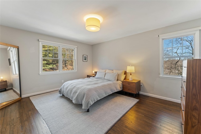 bedroom featuring dark wood-type flooring, multiple windows, and baseboards