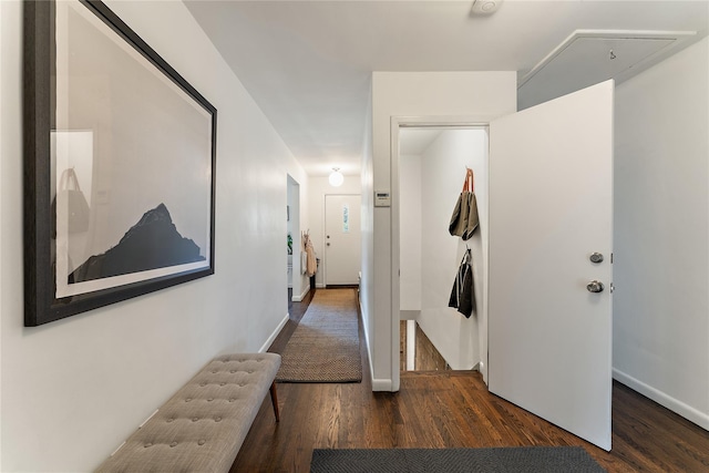 corridor featuring baseboards and wood finished floors