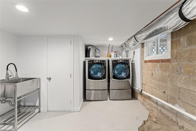 laundry room with recessed lighting, concrete block wall, washing machine and dryer, and laundry area