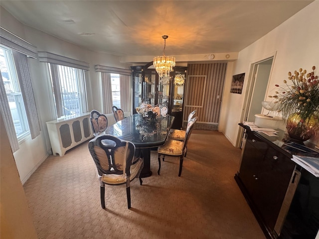 dining space featuring a chandelier and carpet