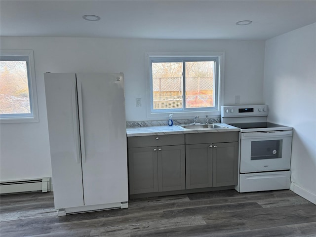 kitchen with a baseboard radiator, sink, gray cabinetry, a healthy amount of sunlight, and white appliances