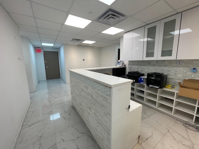 kitchen with white cabinetry, a paneled ceiling, and kitchen peninsula