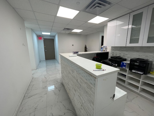 kitchen featuring white cabinetry, a paneled ceiling, and a center island