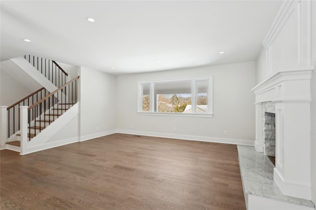 unfurnished living room featuring dark wood-type flooring and a high end fireplace