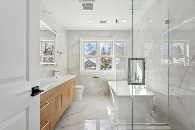 bathroom with tile walls, vanity, an enclosed shower, and toilet