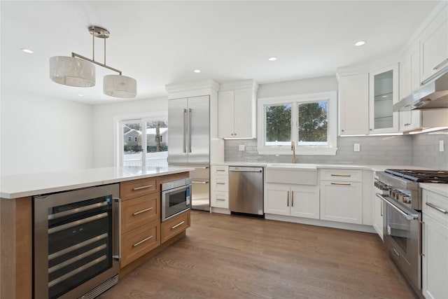 kitchen featuring wine cooler, premium appliances, and white cabinets