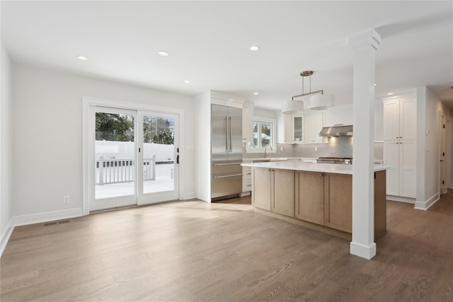 kitchen featuring a center island, pendant lighting, white cabinets, hardwood / wood-style flooring, and tasteful backsplash