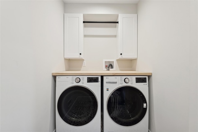 clothes washing area with cabinets and separate washer and dryer