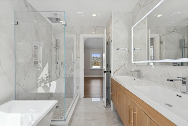 bathroom featuring tile walls, plus walk in shower, and vanity